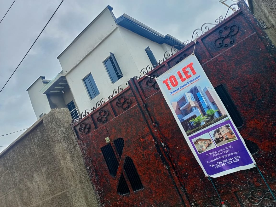 Red metal gate entrance to residential property in Lagos